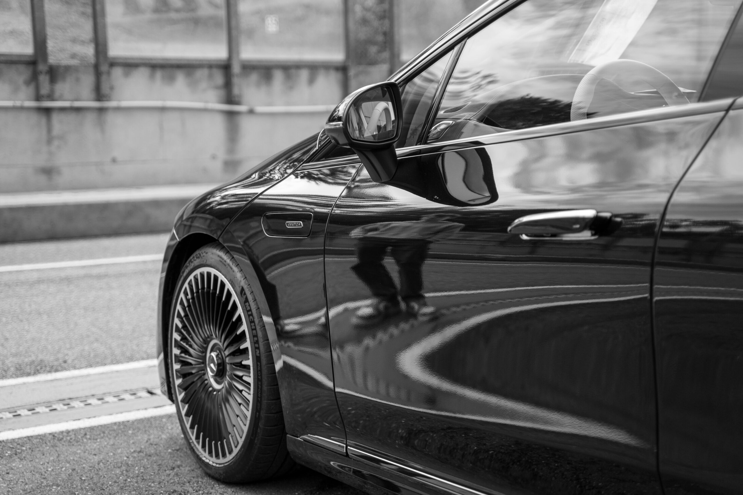 A sleek, luxury black car driving through downtown Chicago, representing premium private transportation